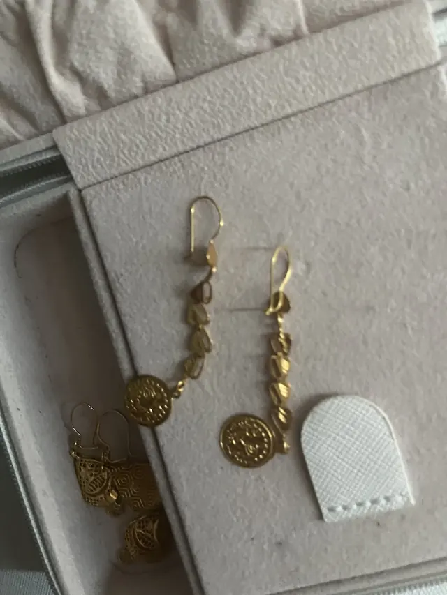 Gold drop earrings in a jewellery case