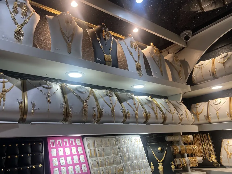 Gold necklaces and chains displayed on the shelves inside the shop